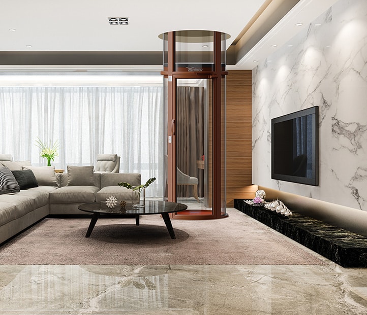 A living room with a Nibav Lifts USA air-driven home elevator in the center. The elevator is circular and has a brown frame and glass walls. The surrounding living room is spacious and has a lot of natural light.